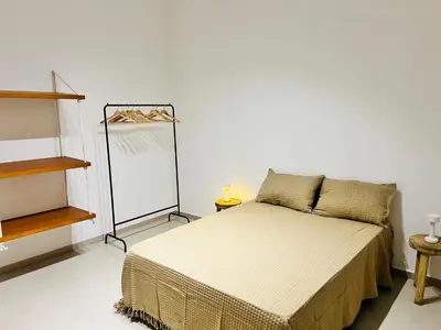 a bedroom with a bed in a white room at Estadio Kempes Valle escondido Centro de Convenciones Amplio y Luminoso in Cordoba