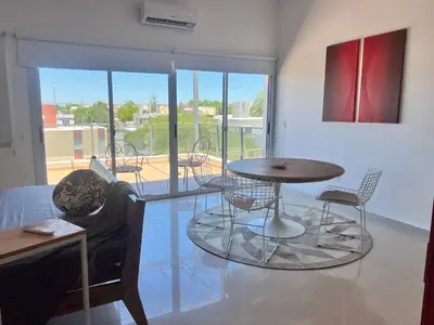a room with a table and chairs and a balcony at Estadio Kempes Valle escondido Centro de Convenciones Amplio y Luminoso in Cordoba