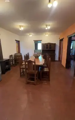 a living room with a wooden table and chairs at Casona de Montaña in Los Hornillos
