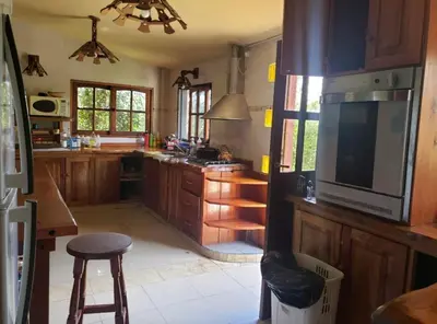 a kitchen with wooden cabinets and a large television at Casona de Montaña in Los Hornillos
