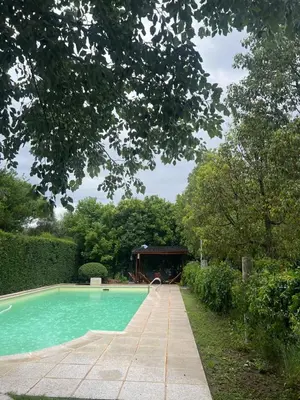 a swimming pool with a building in the background at Cabañas la Huerta in Las Tapias