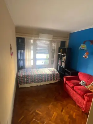 a bedroom with a bed and a red couch at Piso Ejecutivo PREMIUM in Cordoba