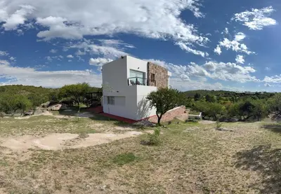 a house on top of a field with trees at Villa Las Medulas - Los Ancares Resort in Mina Clavero
