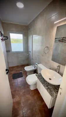 a bathroom with a sink and a toilet and a sink at Villa Las Medulas - Los Ancares Resort in Mina Clavero