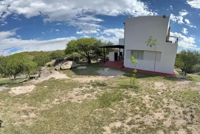 a house in the middle of a field at Villa Las Medulas - Los Ancares Resort in Mina Clavero