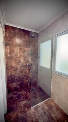 a bathroom with a shower with a glass door at Villa Las Medulas - Los Ancares Resort in Mina Clavero