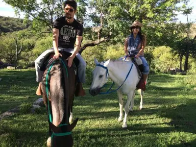 a man and a woman riding on a horse at Villa Las Medulas - Los Ancares Resort in Mina Clavero