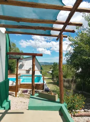 a wooden pergola in front of a house at CABAÑAS L y L in Villa Santa Cruz del Lago