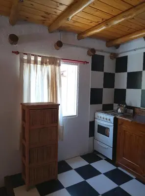 a kitchen with a black and white checkered floor at CABAÑAS L y L in Villa Santa Cruz del Lago