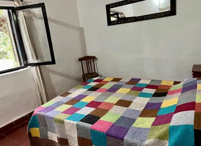 a bedroom with a colorful quilt on a bed at Hospedaje San Javier in San Javier