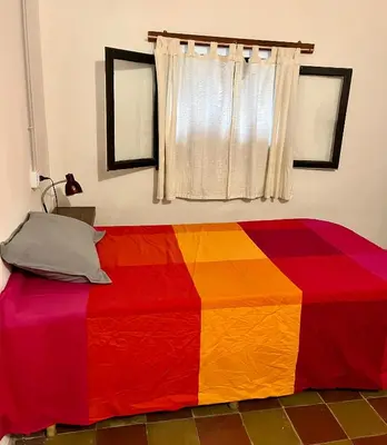 a colorful blanket on a bed in a room at Hospedaje San Javier in San Javier