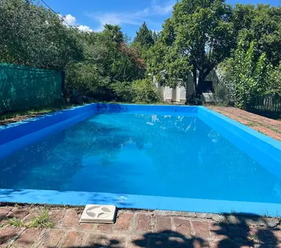a blue swimming pool with a scale in a yard at Hospedaje San Javier in San Javier
