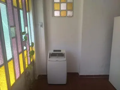 a small refrigerator in a room with a window at El Rincón Bucólico in Cordoba