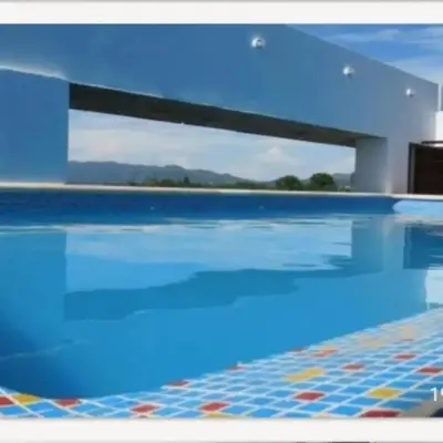a swimming pool with blue water and a tile floor at Departamento en Villa Carlos Paz edificio tempo! in Villa Carlos Paz