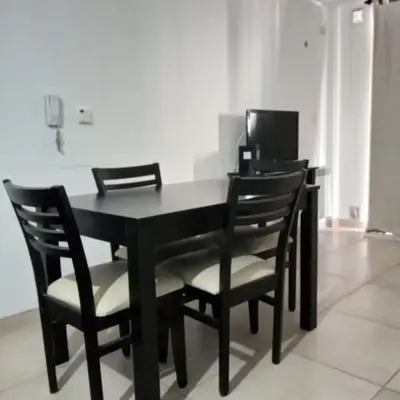 a black dining room table with black chairs at Departamento en Villa Carlos Paz edificio tempo! in Villa Carlos Paz