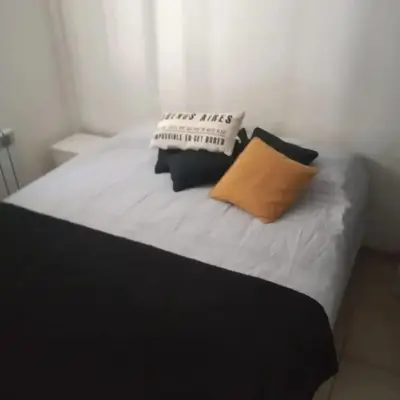 a bed with two pillows on top of it at Departamento en Villa Carlos Paz edificio tempo! in Villa Carlos Paz