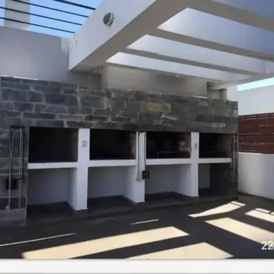 a building with a stone wall in a building at Departamento en Villa Carlos Paz edificio tempo! in Villa Carlos Paz