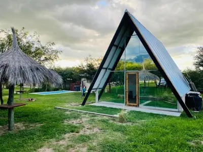 a small house with a triangular roof in a field at Selah in Villa de Las Rosas