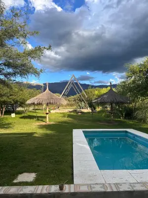 a backyard with a swimming pool and straw umbrellas at Selah in Villa de Las Rosas