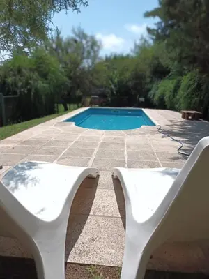 a white bench next to a swimming pool at Cabañas El Tala in La Bolsa