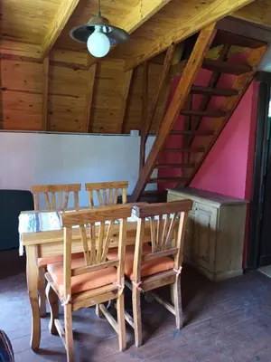 a dining room table with four chairs and a ceiling at Cabañas El Tala in La Bolsa