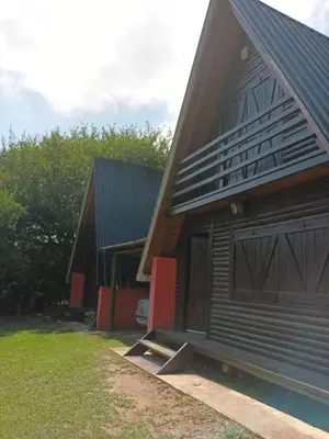 a house with a garage and a building at Cabañas El Tala in La Bolsa