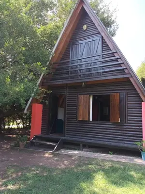 a small house with a gambrel roof at Cabañas El Tala in La Bolsa