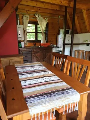 a kitchen with a wooden table with a rug on it at Cabañas El Tala in La Bolsa