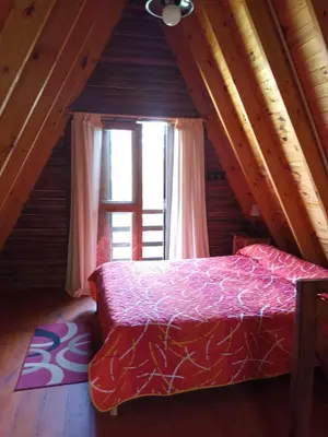 a bedroom with a bed and a large window at Cabañas El Tala in La Bolsa