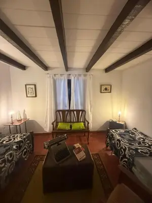 a living room with two beds and a table at Casa en La Falda, Córdoba in Cordoba