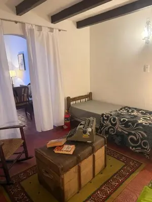 a bedroom with a bed and a sewing machine on a trunk at Casa en La Falda, Córdoba in Cordoba