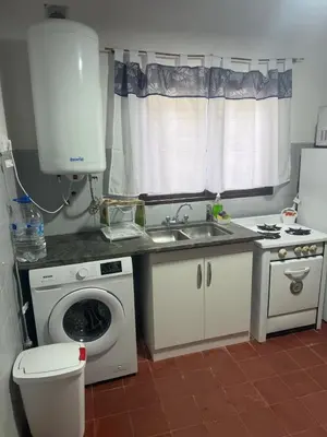 a kitchen with a washing machine and a sink at Casa en La Falda, Córdoba in Cordoba