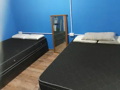 two beds in a room with a mirror at La casona in Bialet Massé