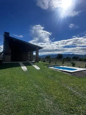 a house with a swimming pool in the grass at RyC La Casita Mirador Del Lago in Villa Parque Siquiman