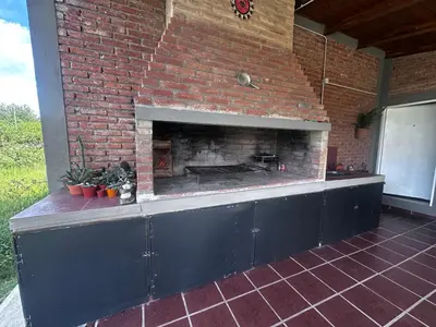 a brick wall with a fireplace on a patio at RyC La Casita Mirador Del Lago in Villa Parque Siquiman