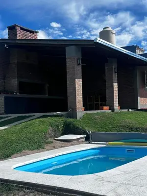 a swimming pool in front of a house at RyC La Casita Mirador Del Lago in Villa Parque Siquiman