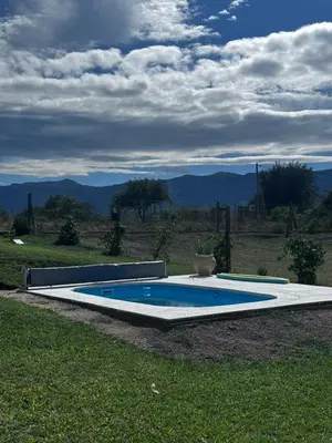 a swimming pool in the middle of a grass field at RyC La Casita Mirador Del Lago in Villa Parque Siquiman