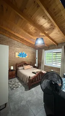 a bedroom with a large bed and a wooden ceiling at Casa de campo, Dique Chico in Villa Anizacate