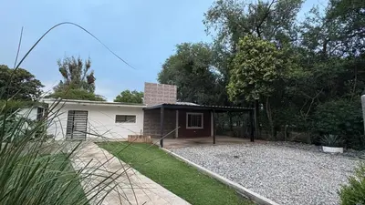 a house with a garage and a yard at Casa de campo, Dique Chico in Villa Anizacate