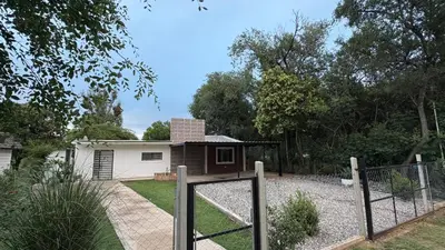 a house with a gate in a yard at Casa de campo, Dique Chico in Villa Anizacate