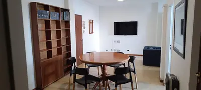 a room with a wooden table and chairs and a television at Departamento Grande 3 Dormitorios con Cochera in Cordoba