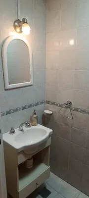 a bathroom with a sink and a mirror and a shower at Departamento Grande 3 Dormitorios con Cochera in Cordoba