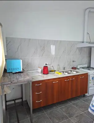 a kitchen with a counter with a sink and a stove at Departamento cerca del rio in Villa Carlos Paz