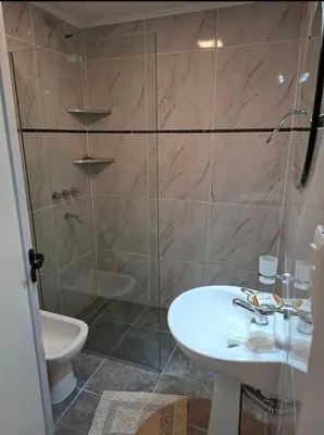 a bathroom with a shower and a sink and a toilet at Departamento cerca del rio in Villa Carlos Paz
