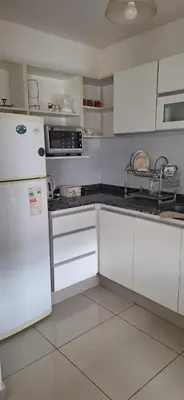 a kitchen with white cabinets and a white refrigerator at Lo de Lili in Cordoba
