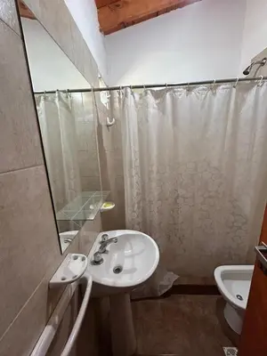 a bathroom with a sink and a shower and a toilet at Alma Ina in Villa Yacanto