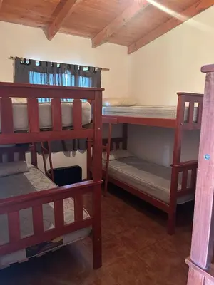 a room with three bunk beds in a room at Alma Ina in Villa Yacanto