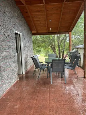 a patio with chairs and a table and a brick wall at Alma Ina in Villa Yacanto