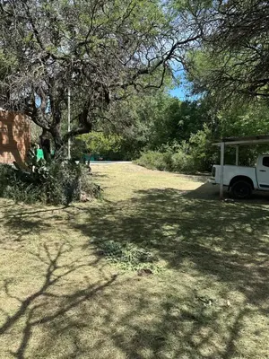 a yard with a tree and a white truck at Green mile in San Roque