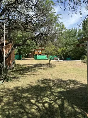 a tree in the middle of a yard with a house at Green mile in San Roque